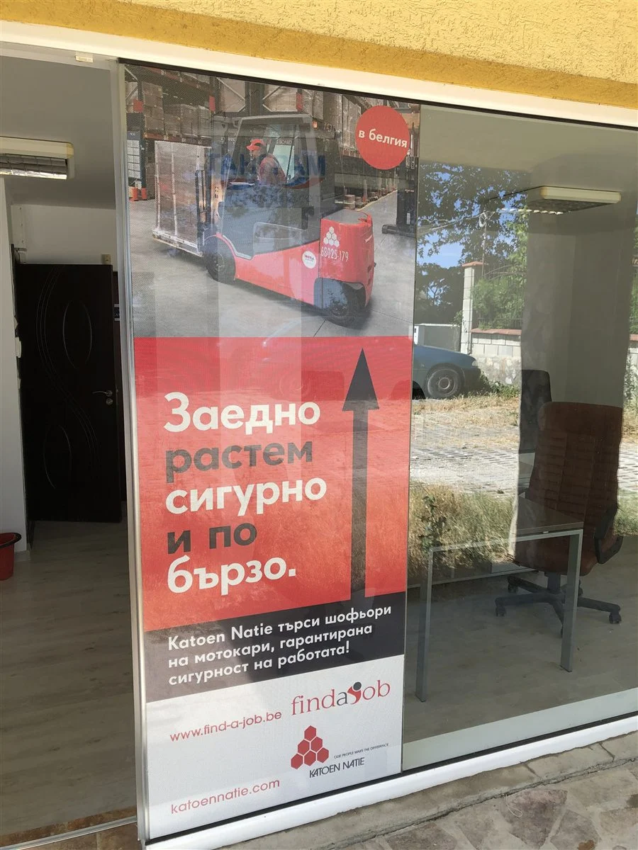 Брандиране на витрини: витрина на офис с перфо фолио — отвън рекламата, през стъклото се вижда офисът